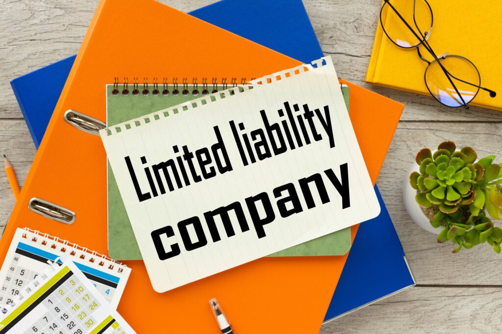 Notebook that says Limited liability company ontop of another notebook and folders