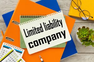 Notebook that says Limited liability company ontop of another notebook and folders